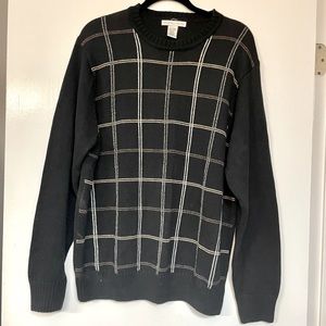 Black sweater with gray, beige, and taupe lines to form checks.